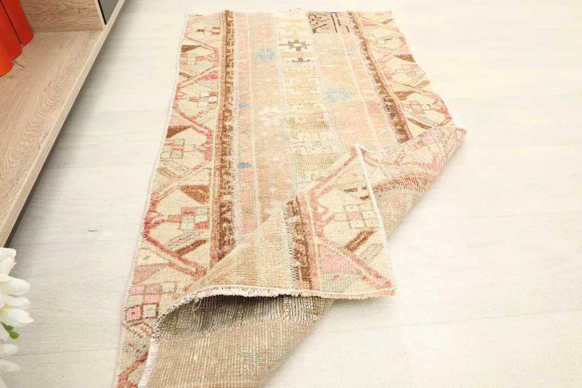 Partial view of the rug with a corner folded back, displaying the underside.