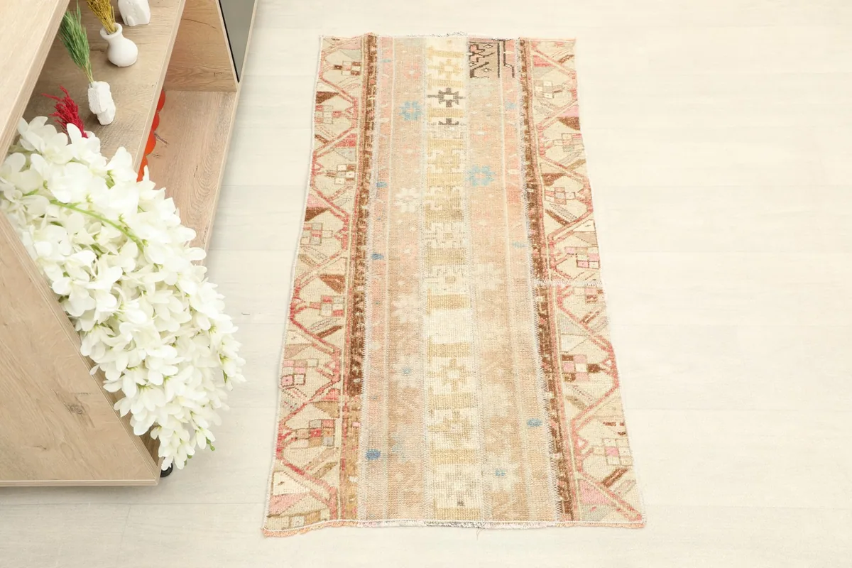 Overhead view of the vintage Anatolian rug, showcasing its beige field and geometric patterns.