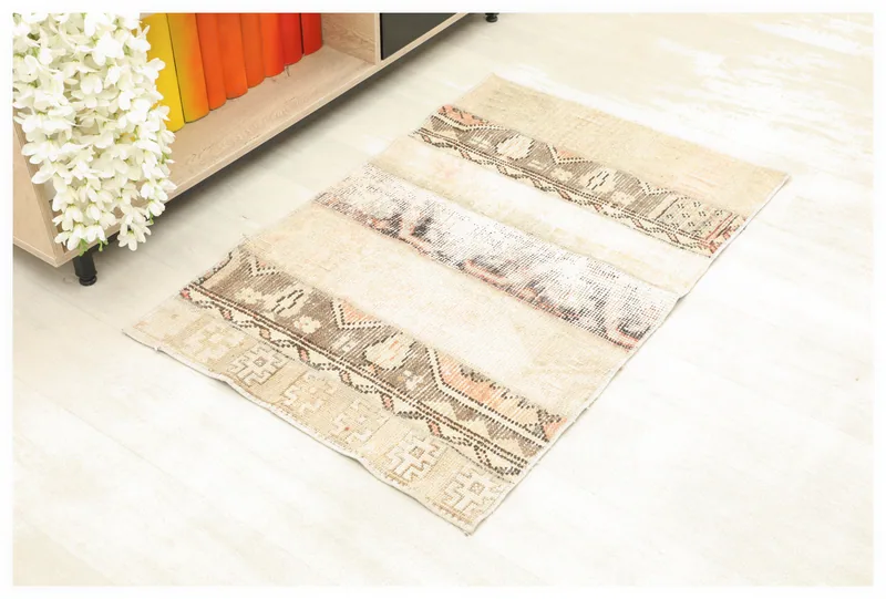 Full overhead view of the beige and brown patchwork vintage Anatolian rug on a white background.