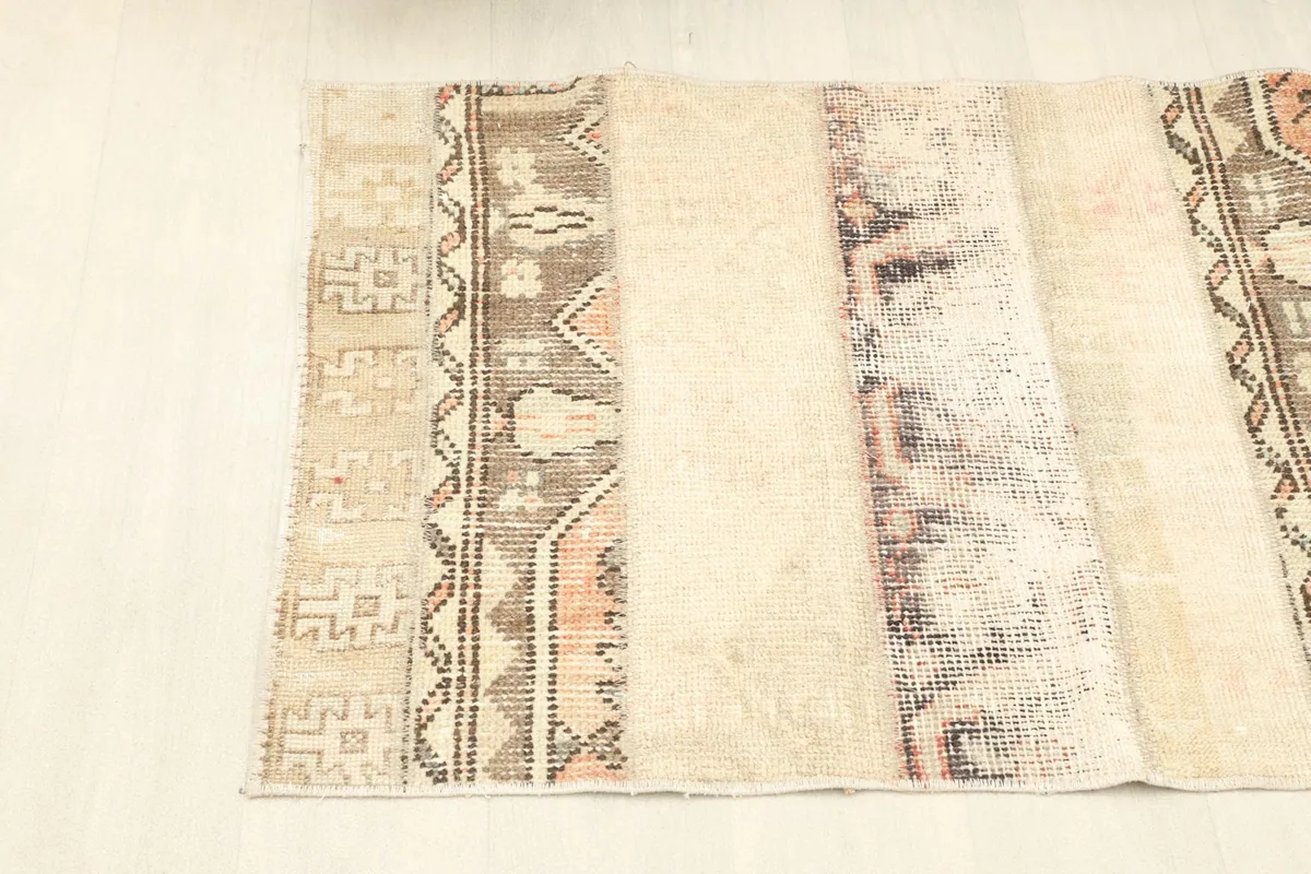 Angled view of the rug's full length, showing the arrangement of the beige and patterned strips.