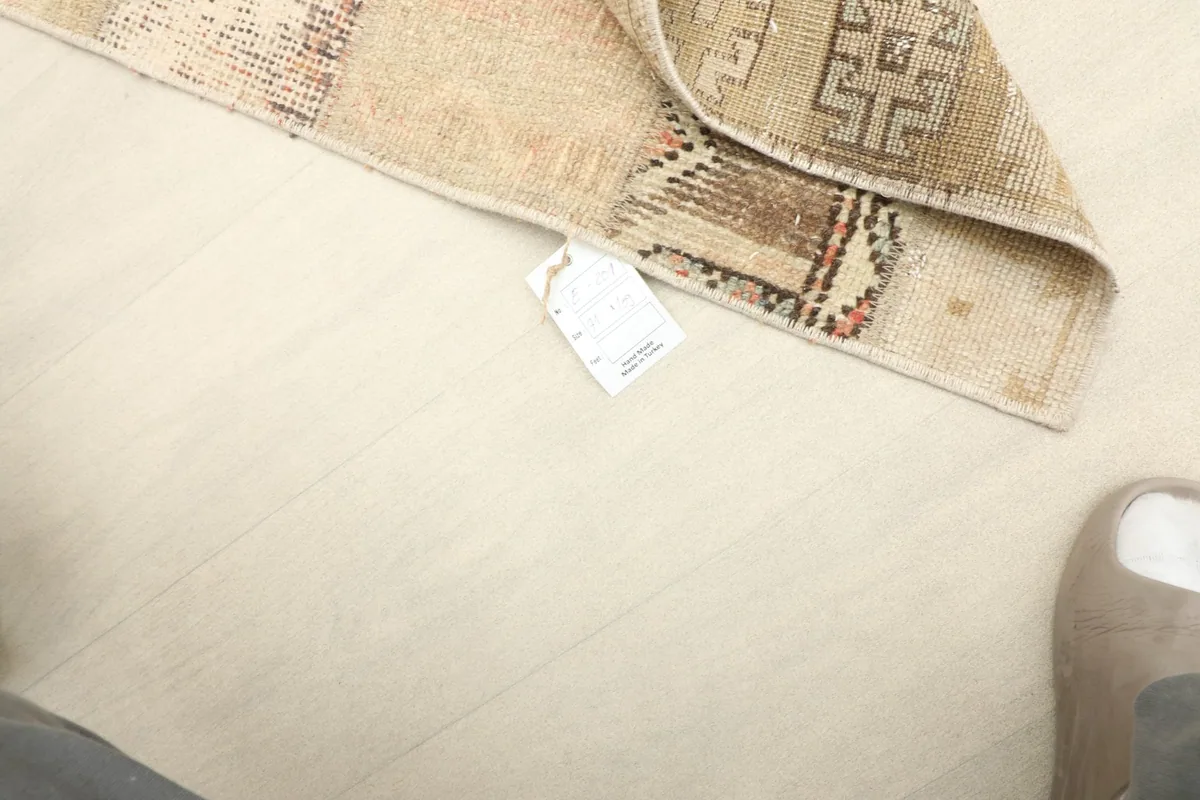 View of the rug's back, indicating the wool pile on cotton foundation and showing a tag.