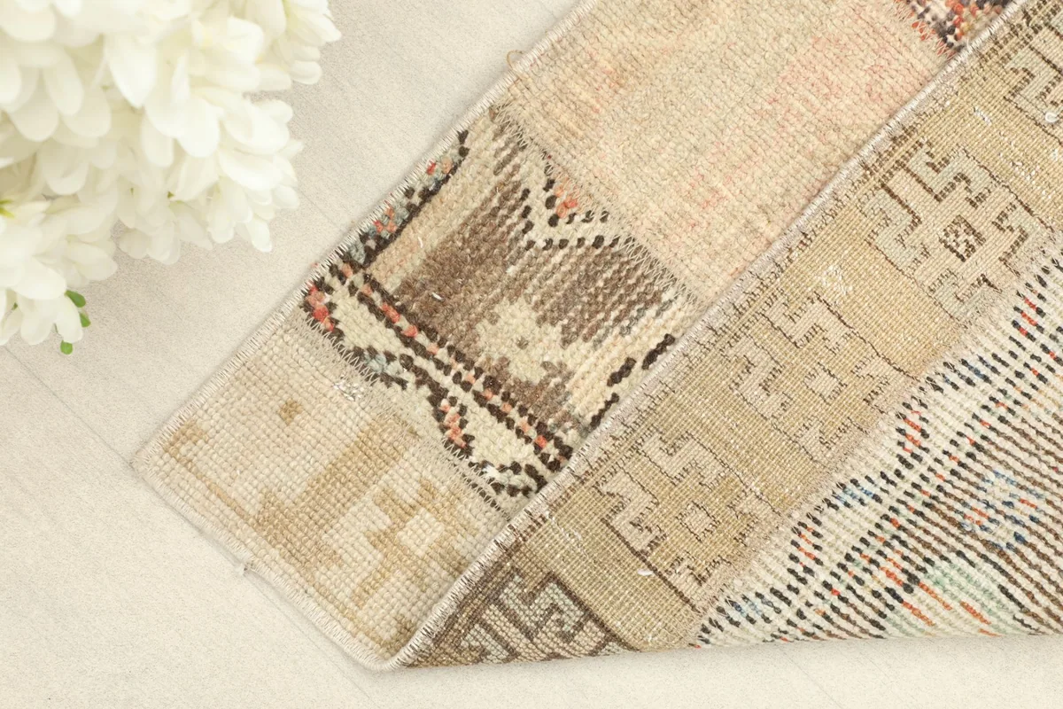 Corner of the rug folded to reveal the backing and the hand-knotted construction.