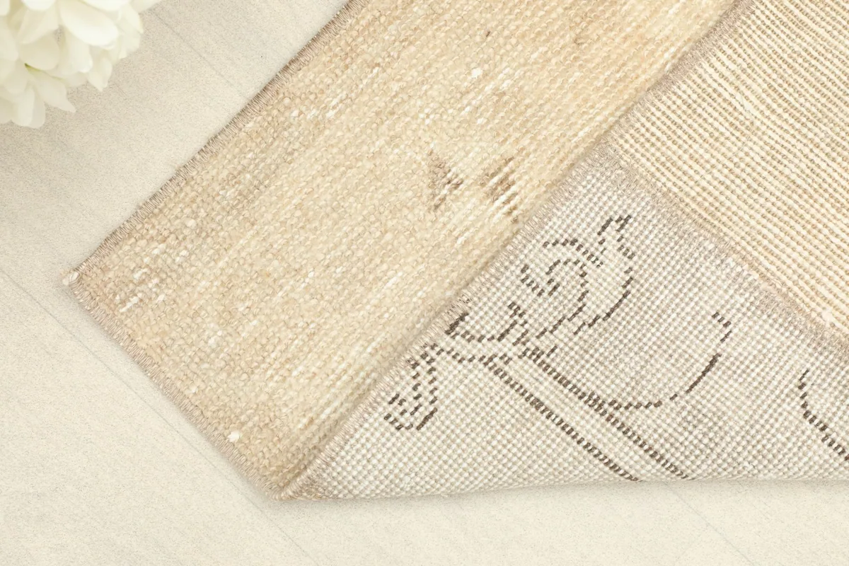 Corner folded back, revealing the cotton foundation and the reverse of the hand-knotted wool pile.