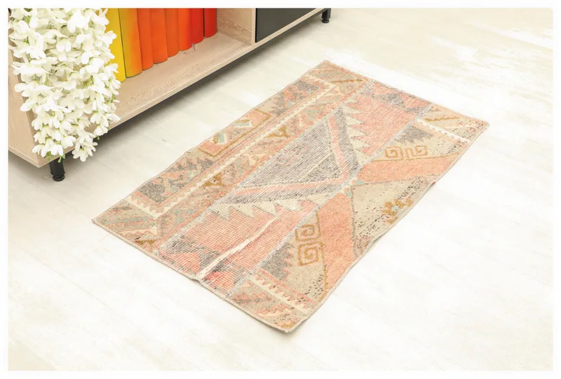 Full top view of the rose and beige geometric patchwork runner rug on a white background.