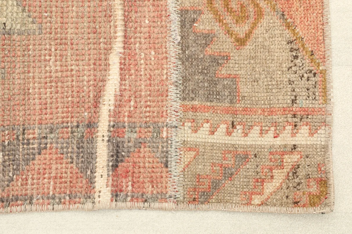 Close-up detail of the hand-knotted wool pile and stitching where different rug pieces meet.