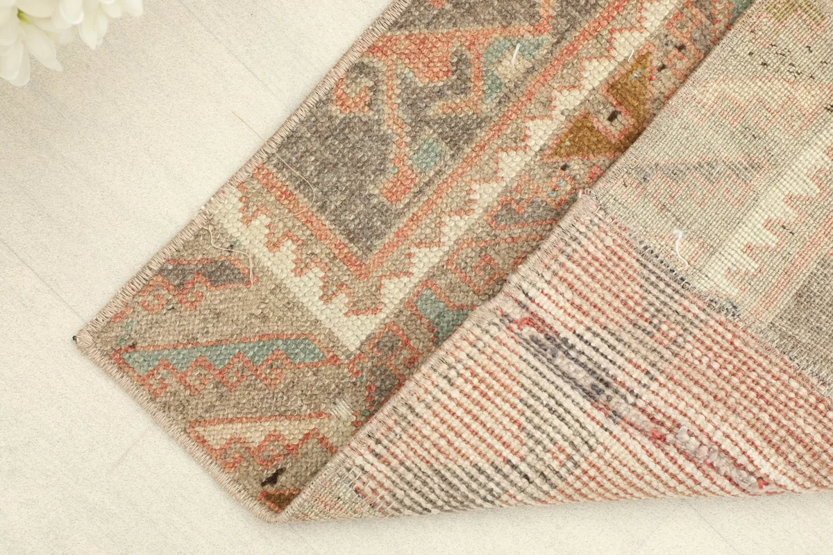 View of the rug's underside, showing the cotton foundation and the reverse of the hand-knotted construction.