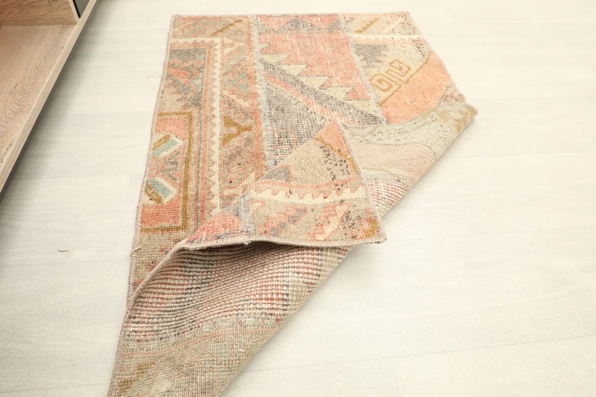 Rug folded to display the thickness of the wool pile and the construction from a side perspective.