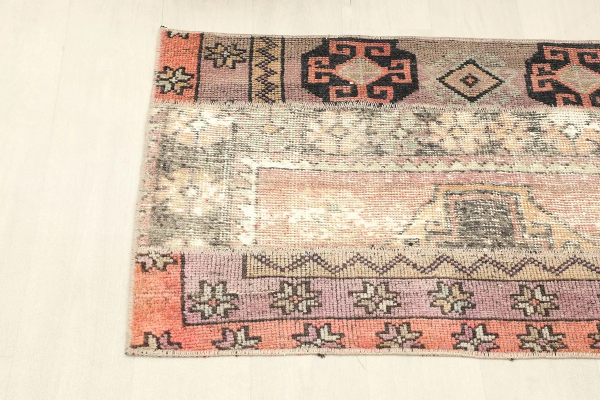 Detailed view of one side of the rug, focusing on the distinct patchwork panels and border patterns.