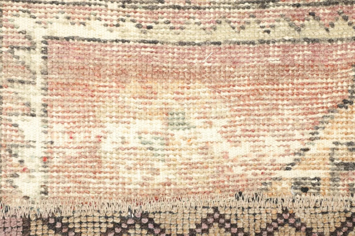Extreme close-up of the low wool pile, revealing the hand-knotted texture and color variations.