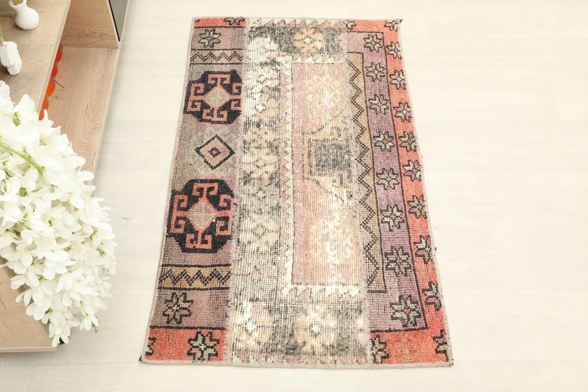 Overhead view of the vintage Anatolian rug, highlighting its patchwork design and colors.