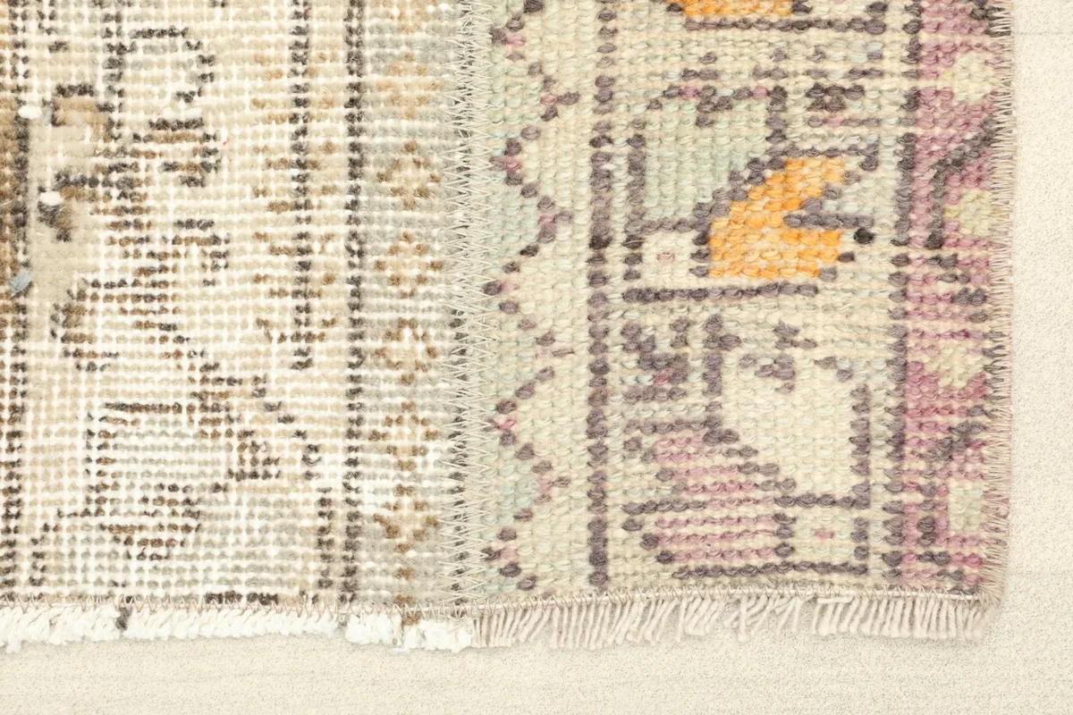 Close-up detail of the rug's edge, highlighting the hand-knotted wool pile and fringe