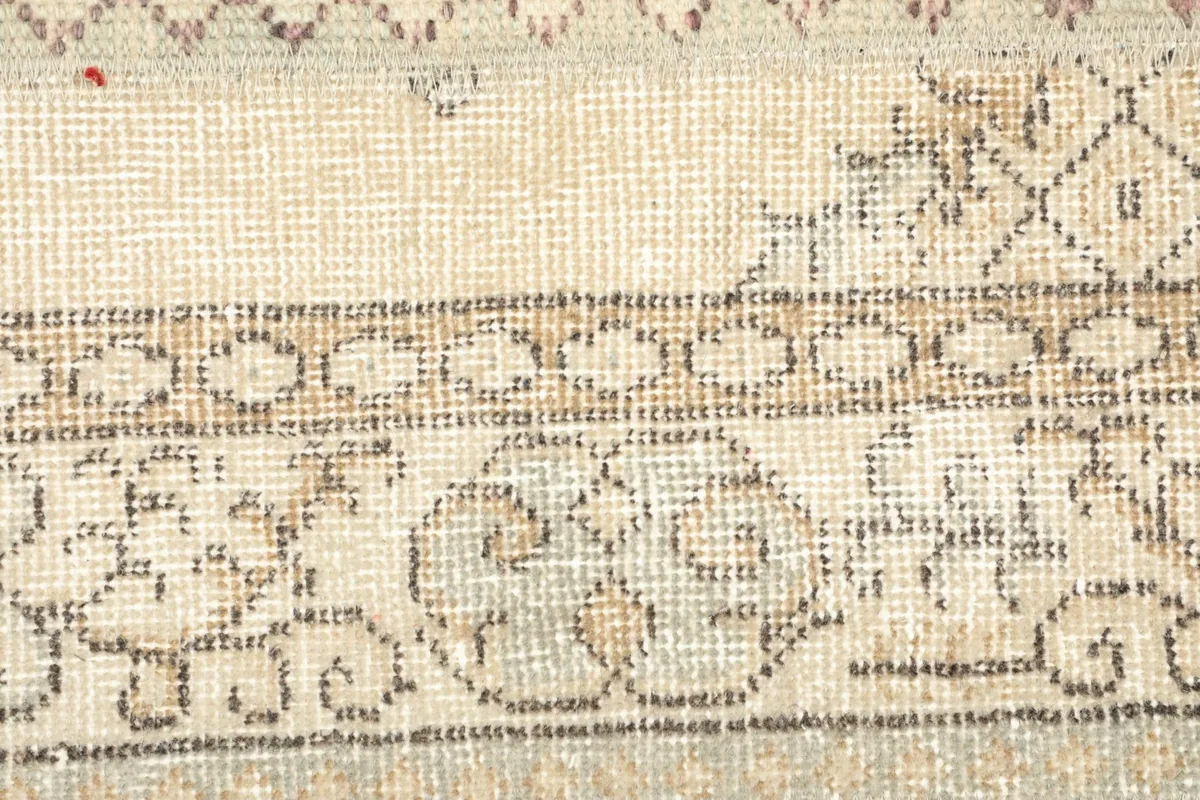 Detailed view of the rug's central section, revealing subtle patterns and variations in the ivory wool