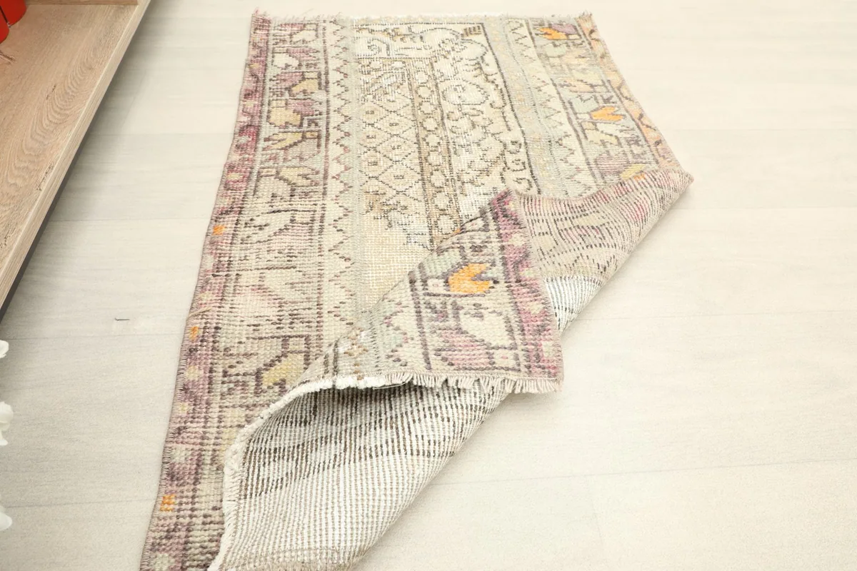 Rug folded to show the thickness and flexibility of the vintage wool material