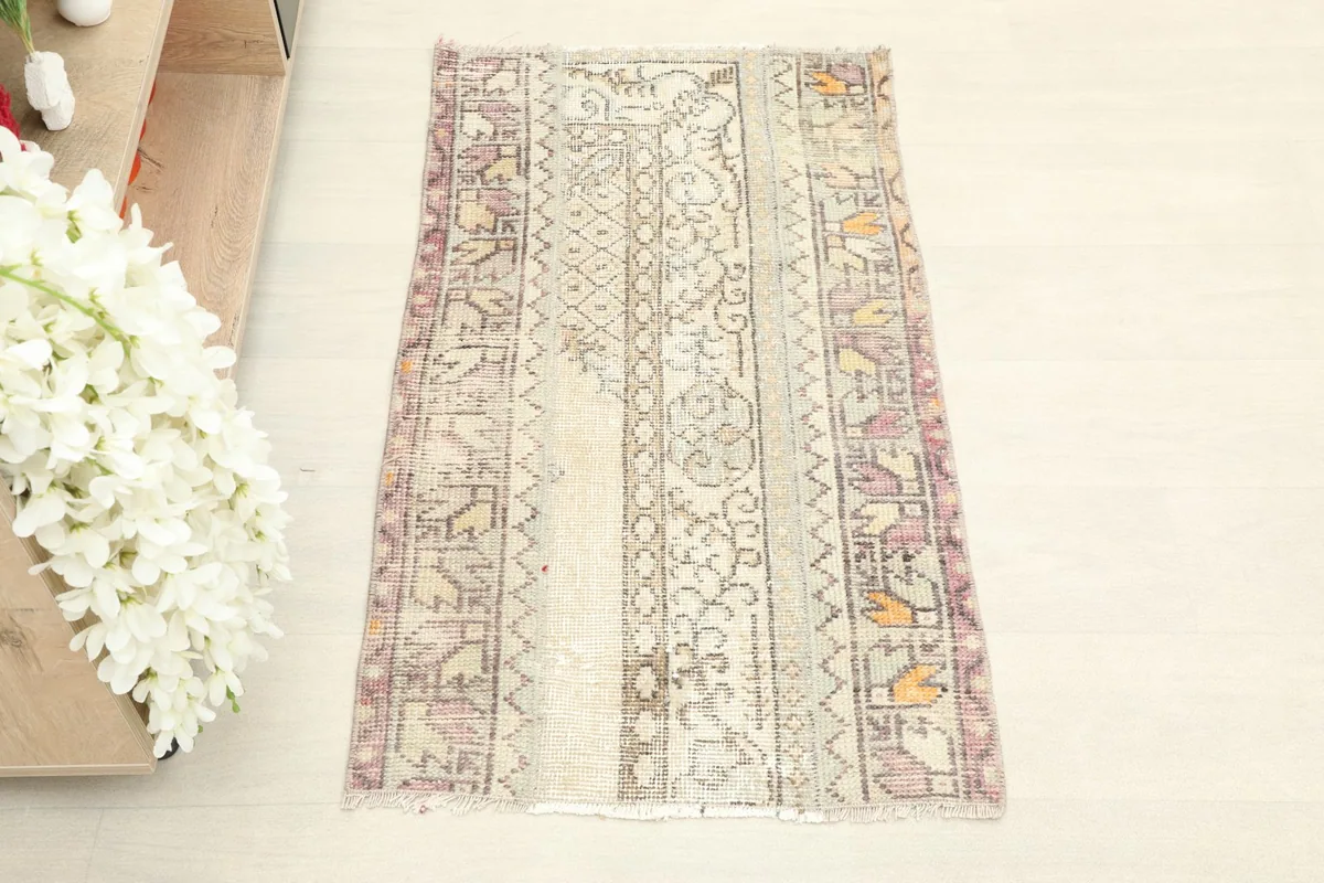 Overhead view of the ivory, purple, and orange vintage rug, showing its full design and colors