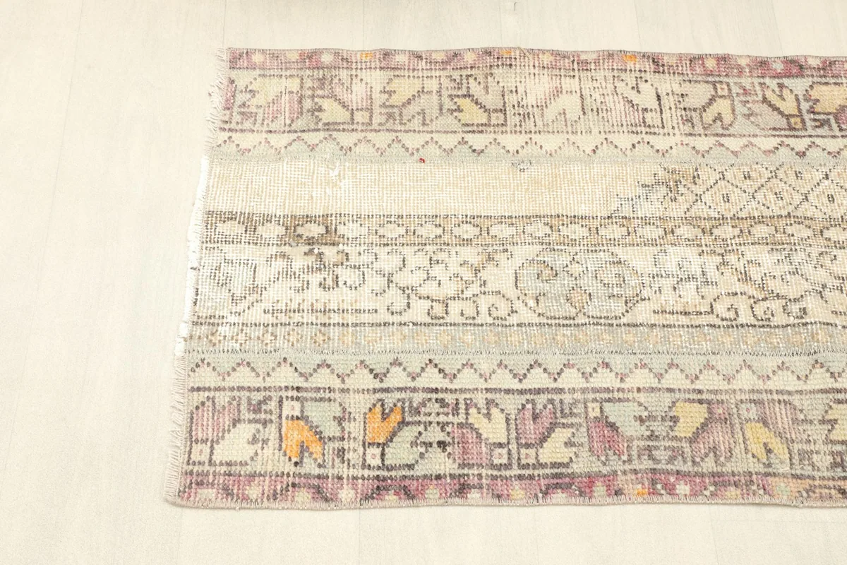 Overhead view of one side of the rug, displaying the distinct striped patchwork and motifs