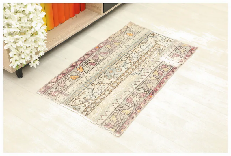 Full top view of the beige and rose vintage Anatolian rug on a white floor.