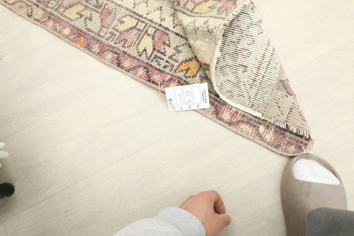Rug shown in a room setting next to a person's foot for scale, highlighting its mini size.