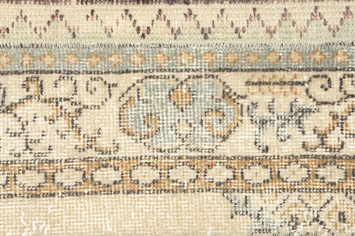 Detailed shot of the central medallion-like motif in blue, beige, and orange.