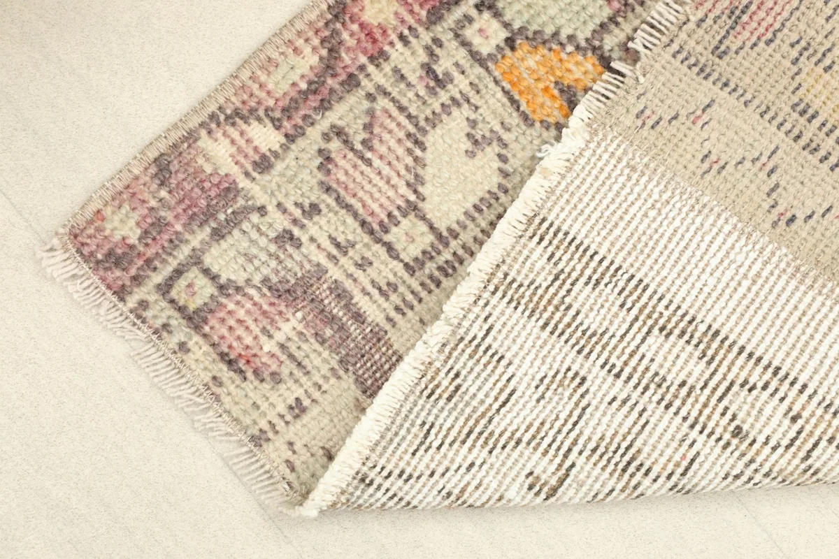 View of the rug's backside and pile, showing the hand-knotted construction and cotton foundation.