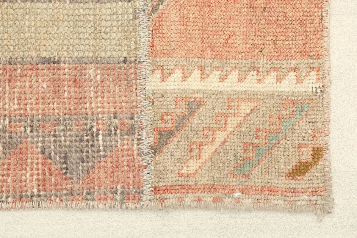 Detailed view of the rug's edge, showcasing the hand-knotted texture and warm color variations