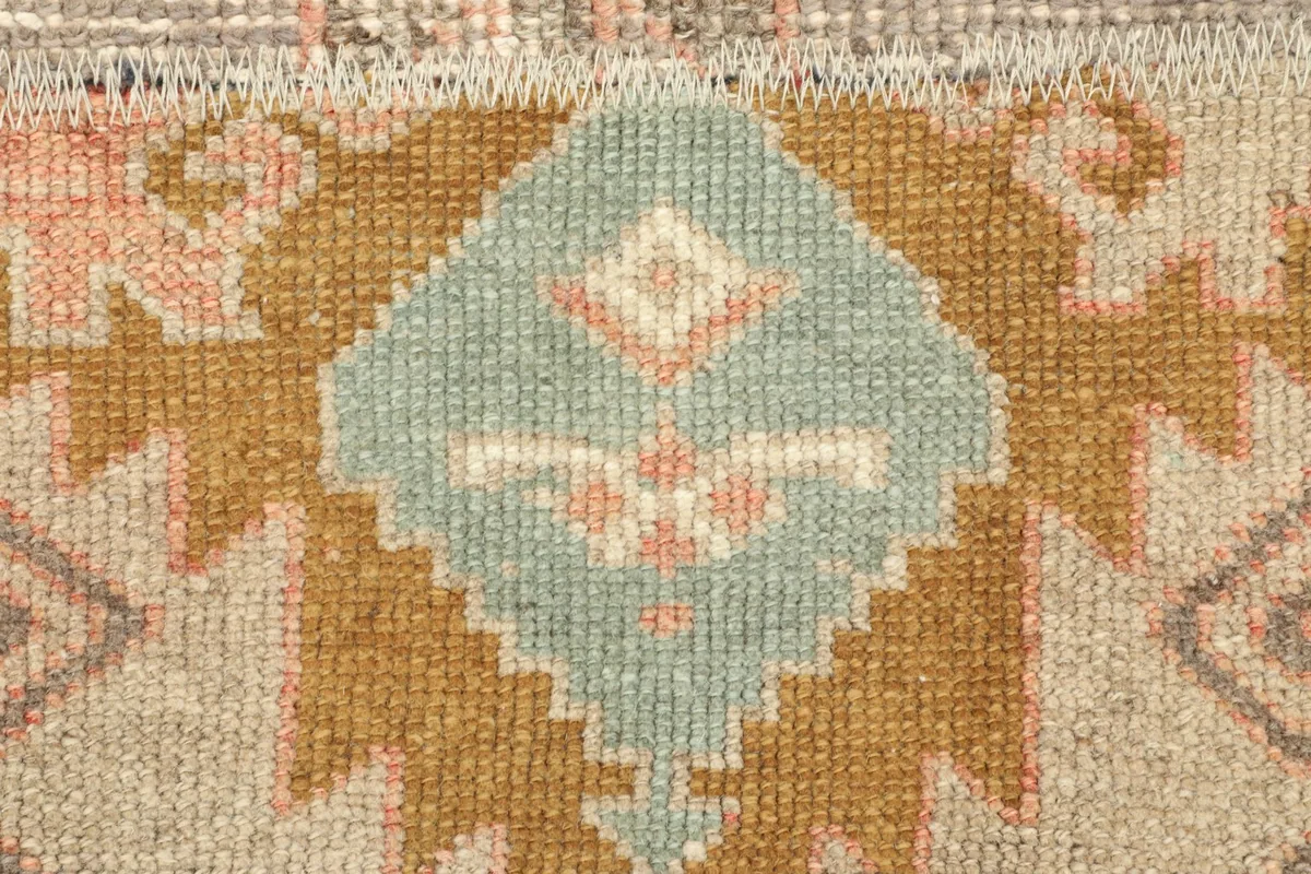 Close-up of a blue and beige geometric motif within the patchwork design of the rug