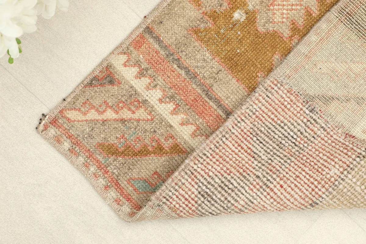 Corner of the rug folded over to reveal the hand-knotted cotton foundation and wool pile