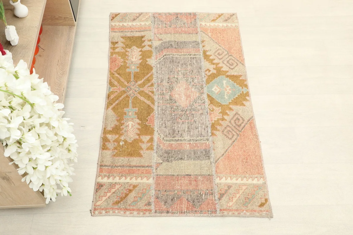Close overhead view of the vintage rug, showing its patchwork geometric patterns and colors