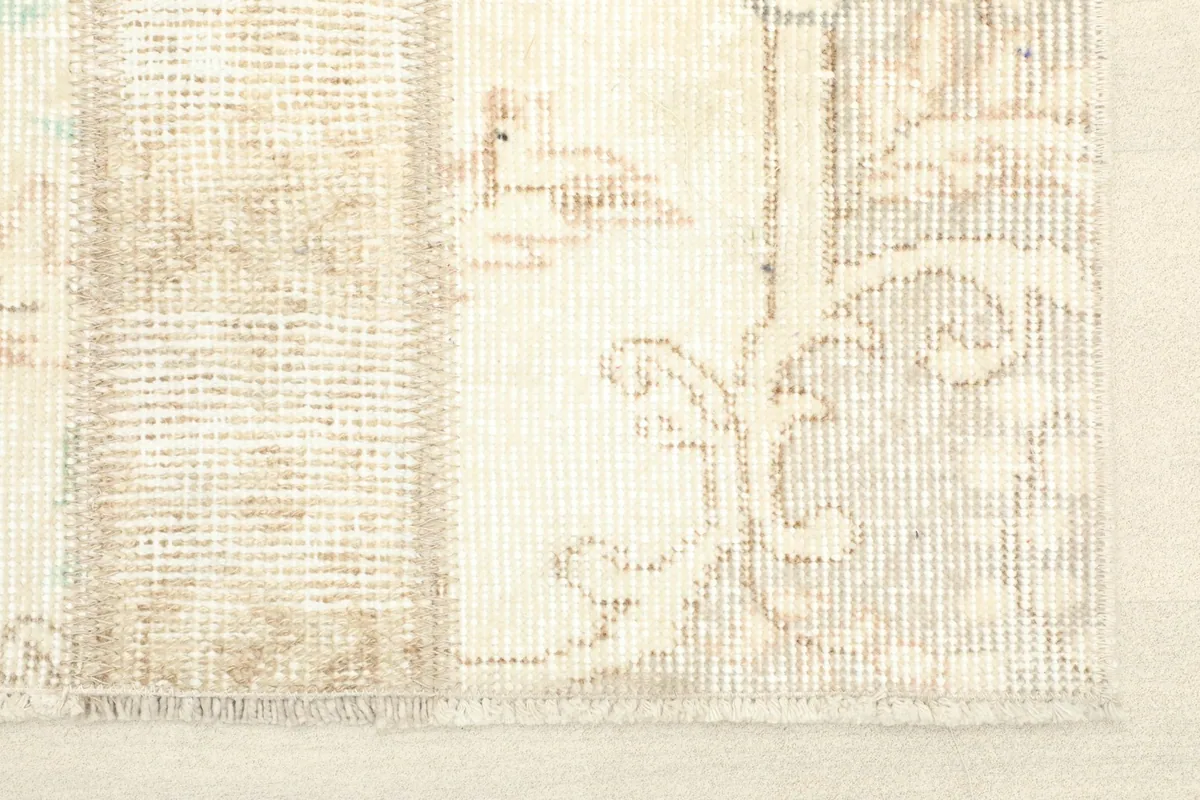 Close-up detail of the rug's border and fringe, showing the distressed wool pile and cotton foundation.