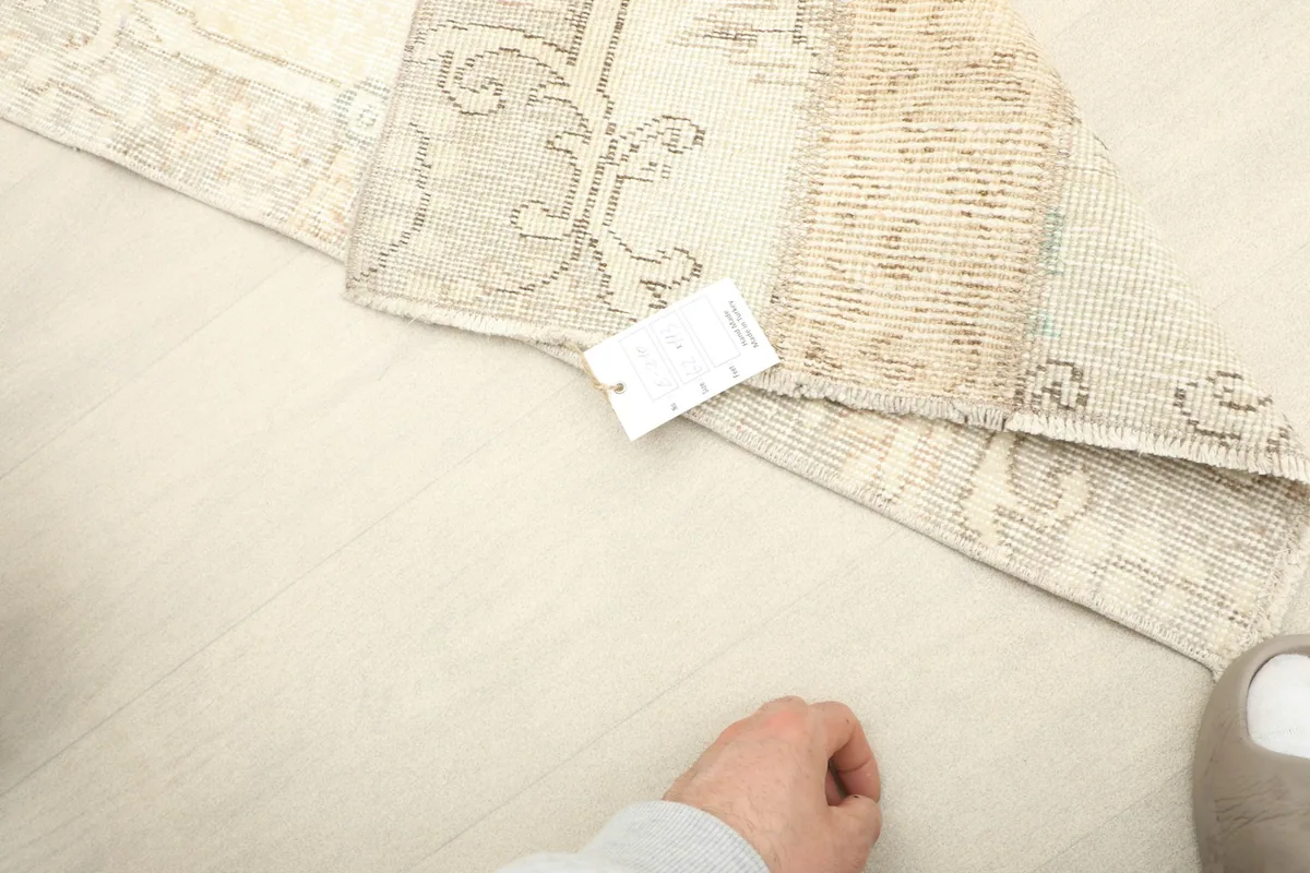 View of the rug's back and foundation, with a size tag visible, demonstrating its authentic construction.