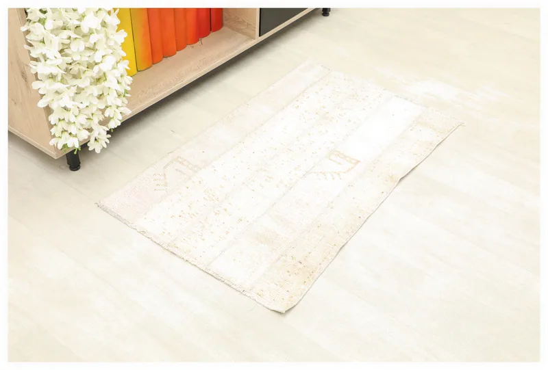 Full top view of the 1'11" x 3'2" beige patchwork vintage rug with geometric patterns