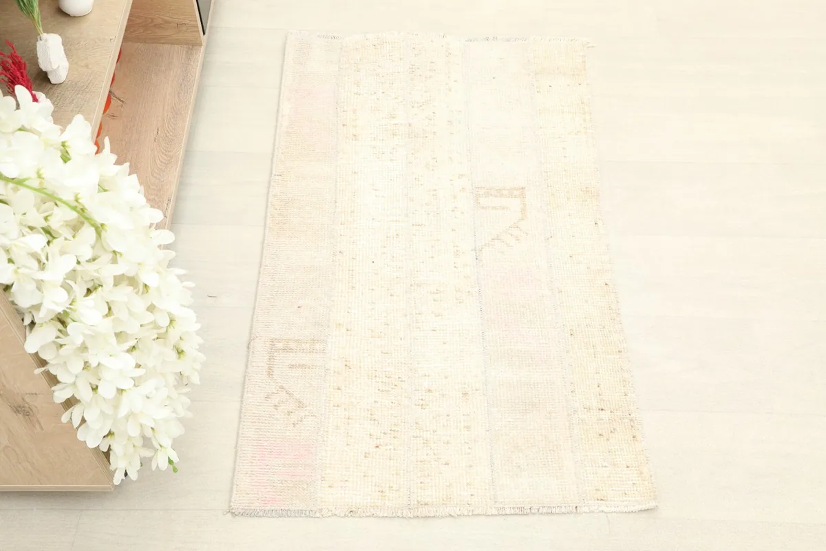 Overhead view of the beige and cream vintage rug, showcasing its overall appearance
