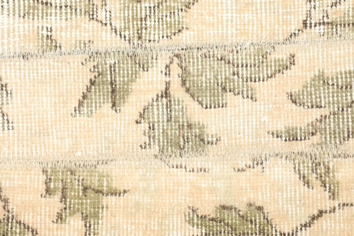 Detailed view of the low wool pile, showing the intricate knotting and color blend of the leaves.