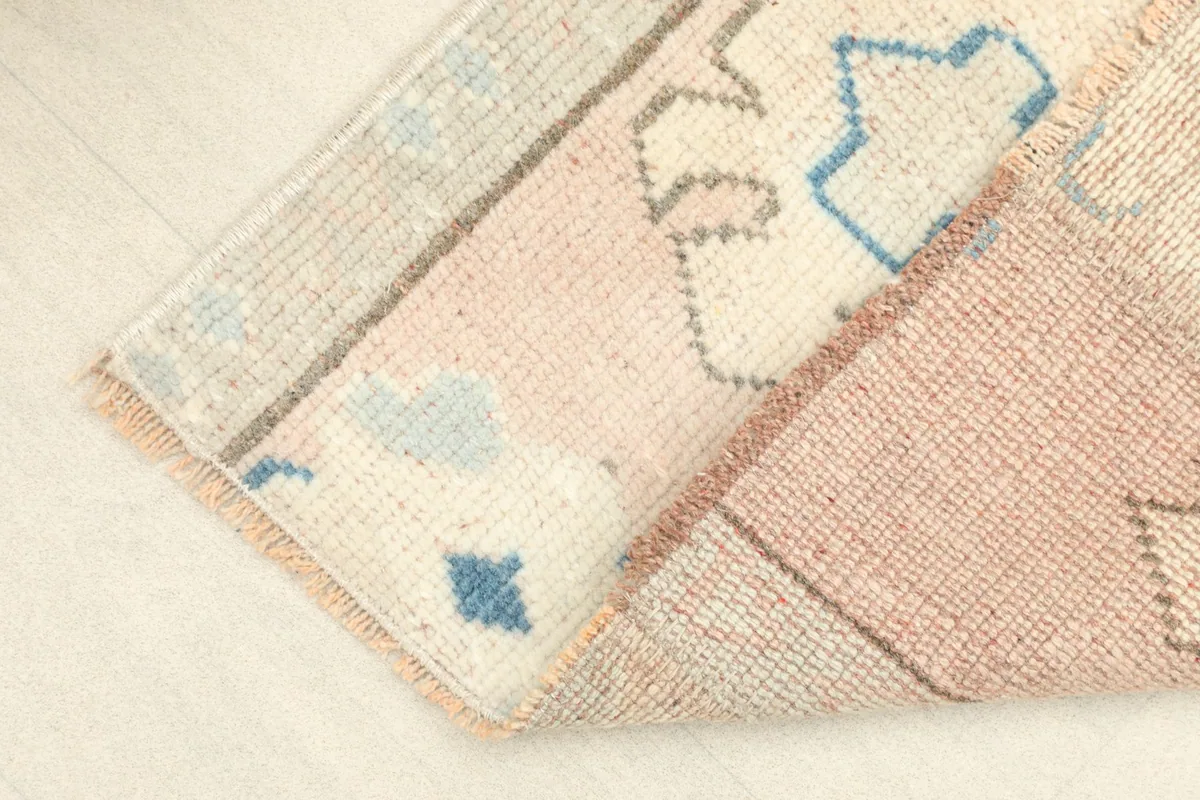 View of the rug's corner, showing the cotton foundation and the reverse side of the hand-knotted pile.