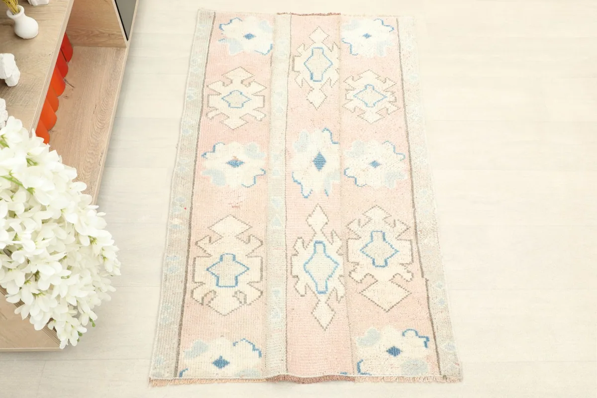 Overhead view of the hand-knotted rug, highlighting its rose field and ivory and blue patterns.