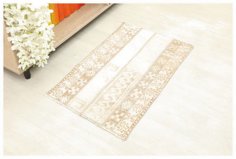 Full overhead view of the beige and tan patchwork vintage Anatolian rug on a white background.