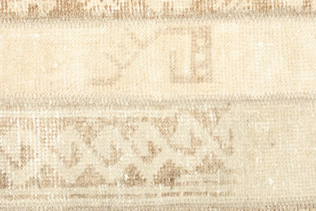 Detailed view of the central patchwork strips, revealing subtle tribal designs in beige and tan.