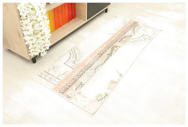 Full overhead view of the ivory and rose patchwork vintage rug on a white background.