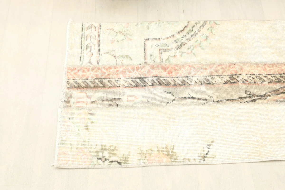 Angled view of the rug from the top, showcasing its elongated shape and patchwork construction.