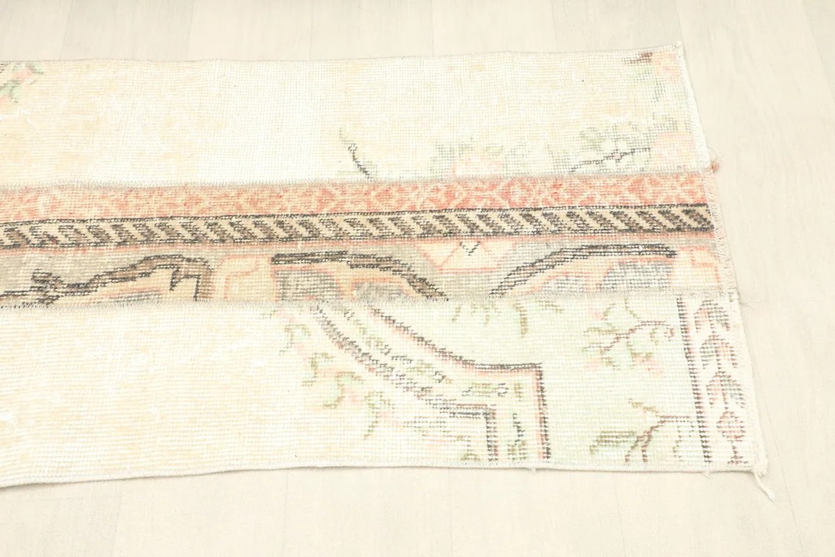 Angled view of the rug from the bottom, showing the blend of different vintage rug pieces.