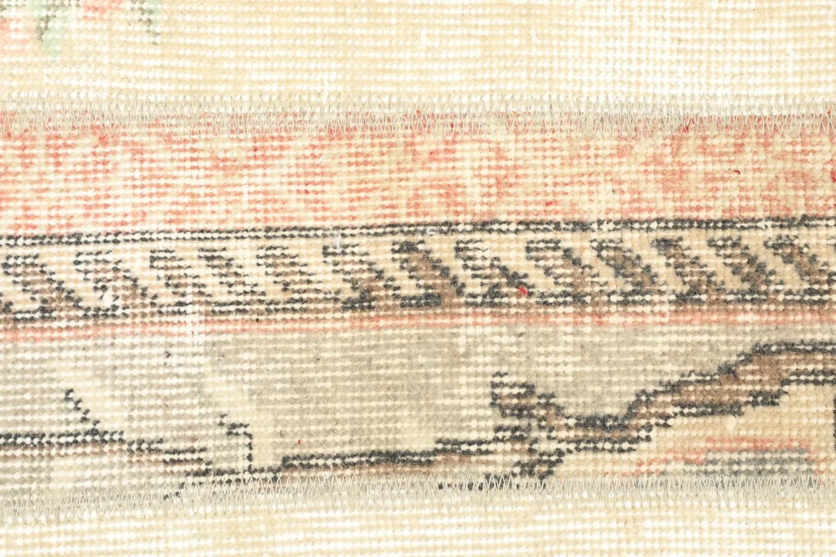 Detailed shot of a central patchwork strip, showing geometric motifs and color variations.