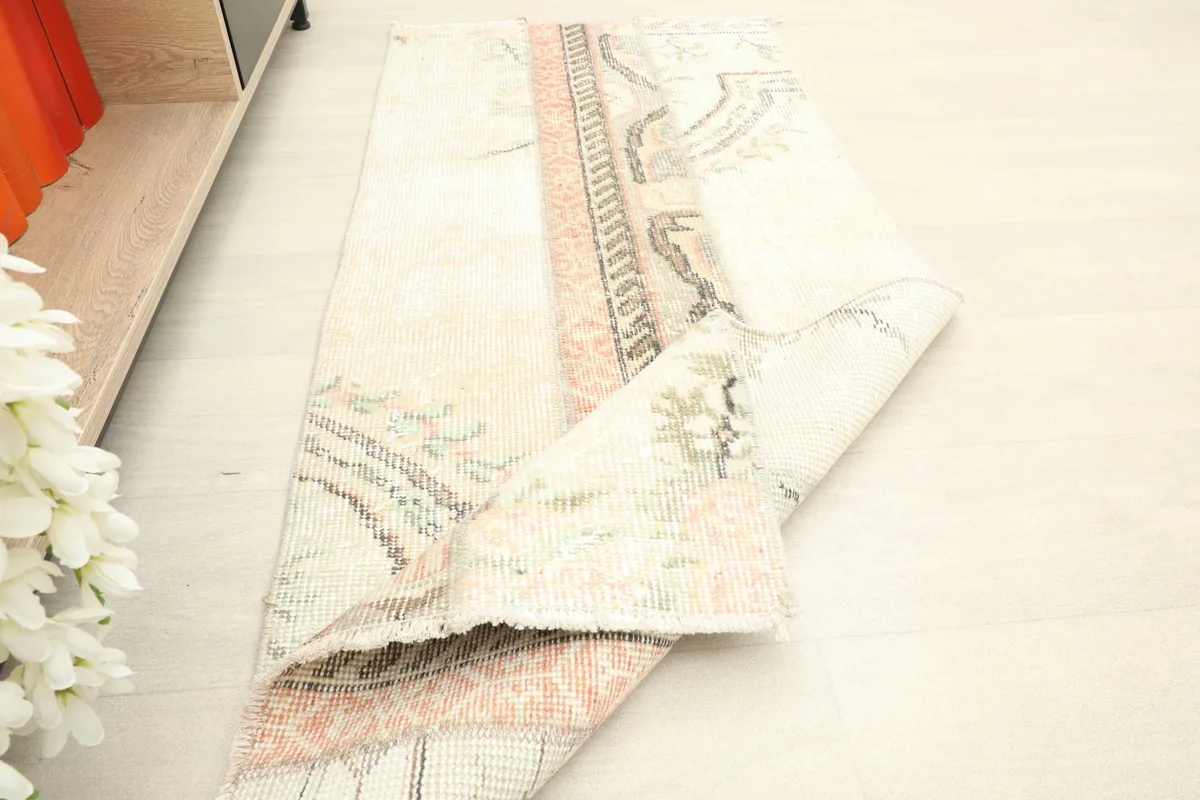 Rug partially folded, illustrating its flexibility and the hand-knotted construction.