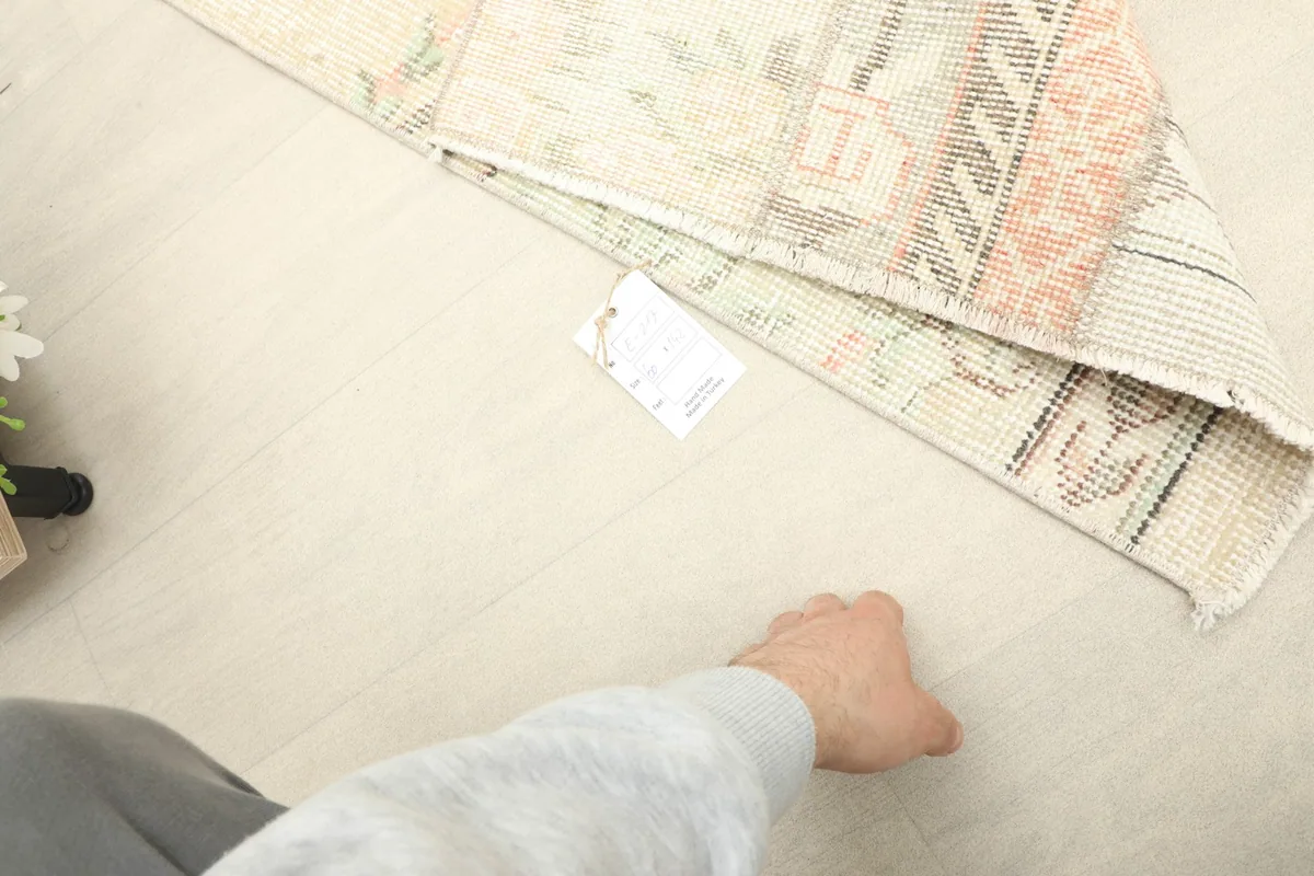 A hand next to the rug to provide a sense of scale for the mini area rug.