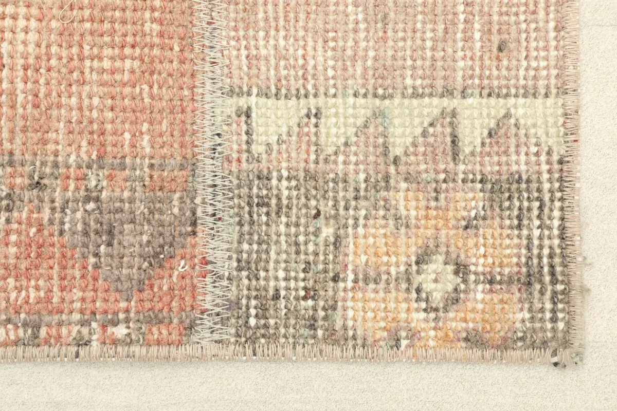 Close-up detail of the rug's patchwork stitching and low wool pile texture.