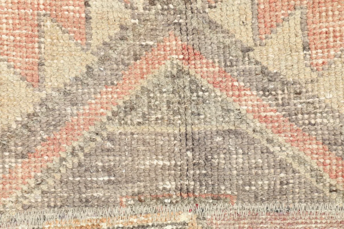 Detailed view of the low pile and intricate knotting of the vintage wool rug.