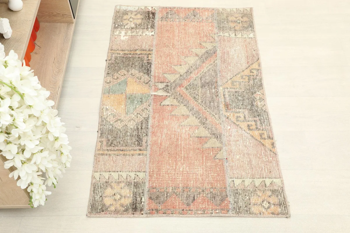 Overhead view of the hand-knotted rust and charcoal patchwork rug, showcasing its full design.