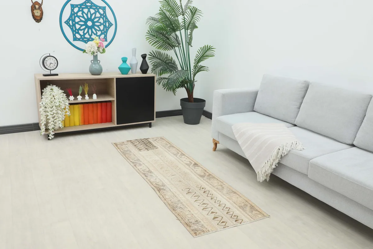 Vintage Anatolian runner rug placed in a modern living space with a couch and console.