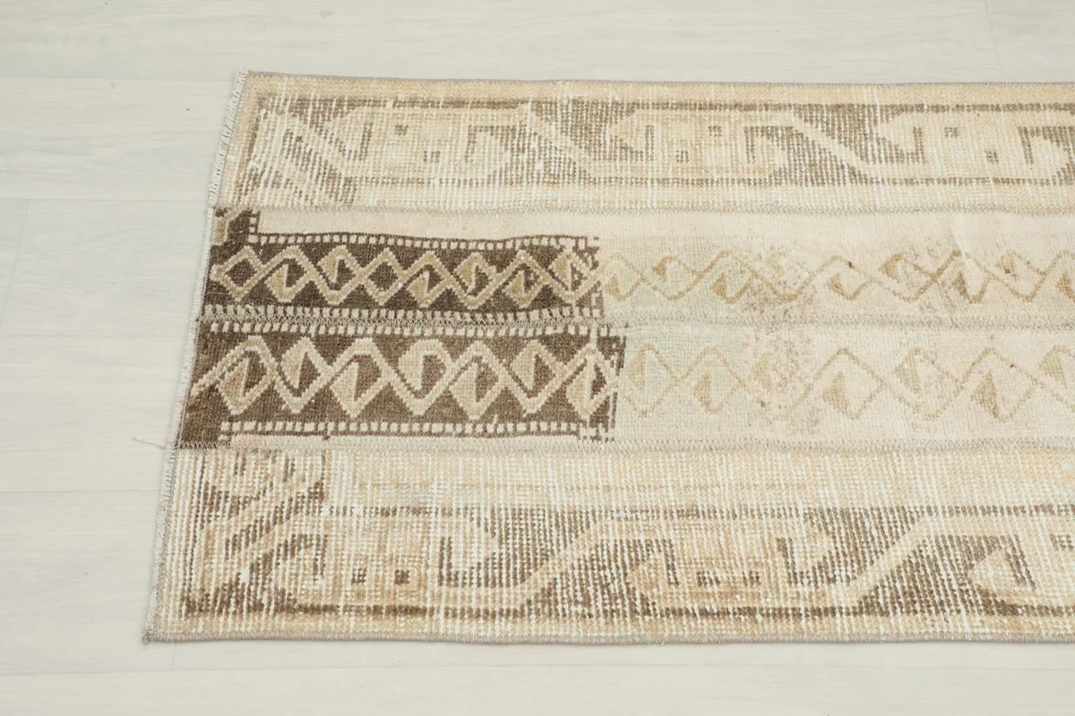 Detailed view of the upper section of the runner, highlighting the darker brown tribal motifs.