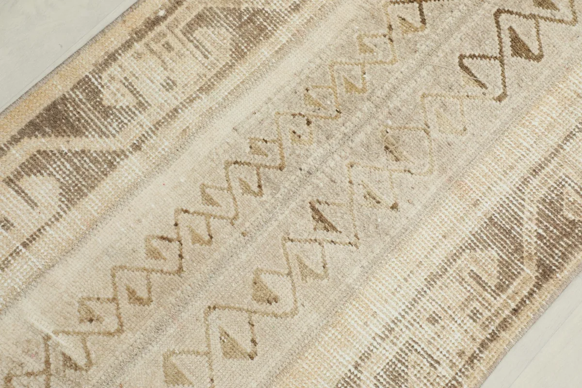 Close-up showing the varied geometric patterns and texture of the hand-knotted wool pile.