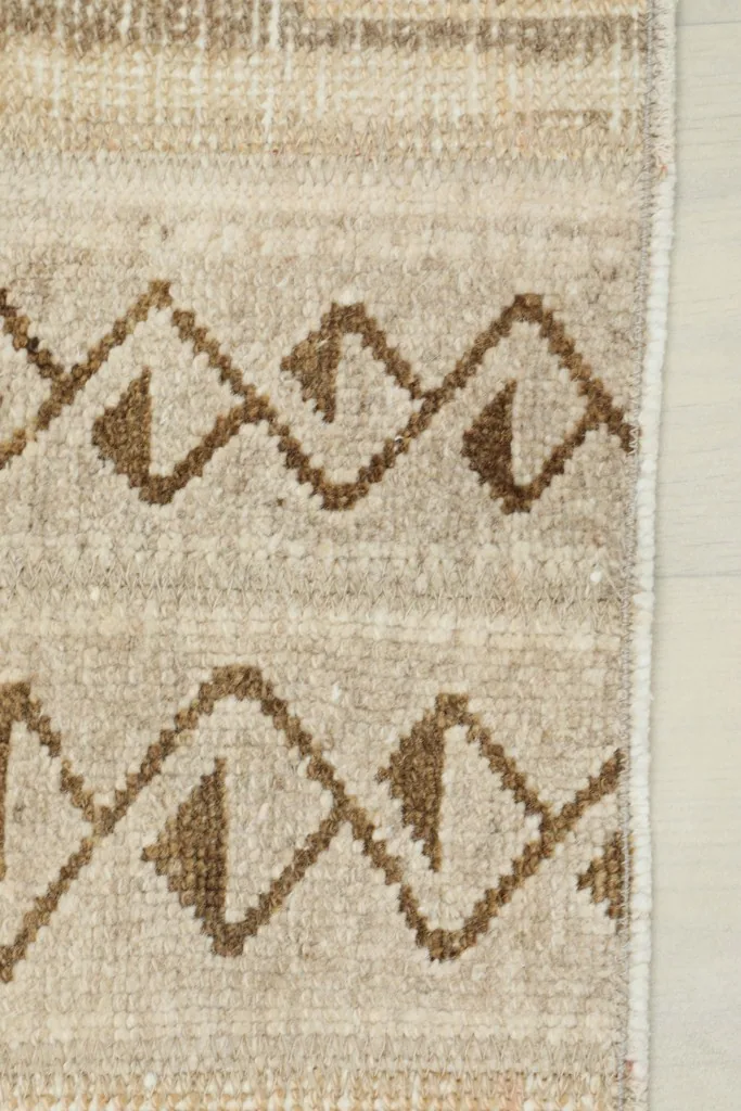 Close-up of the rug's edge, revealing the intricate geometric border and field patterns.