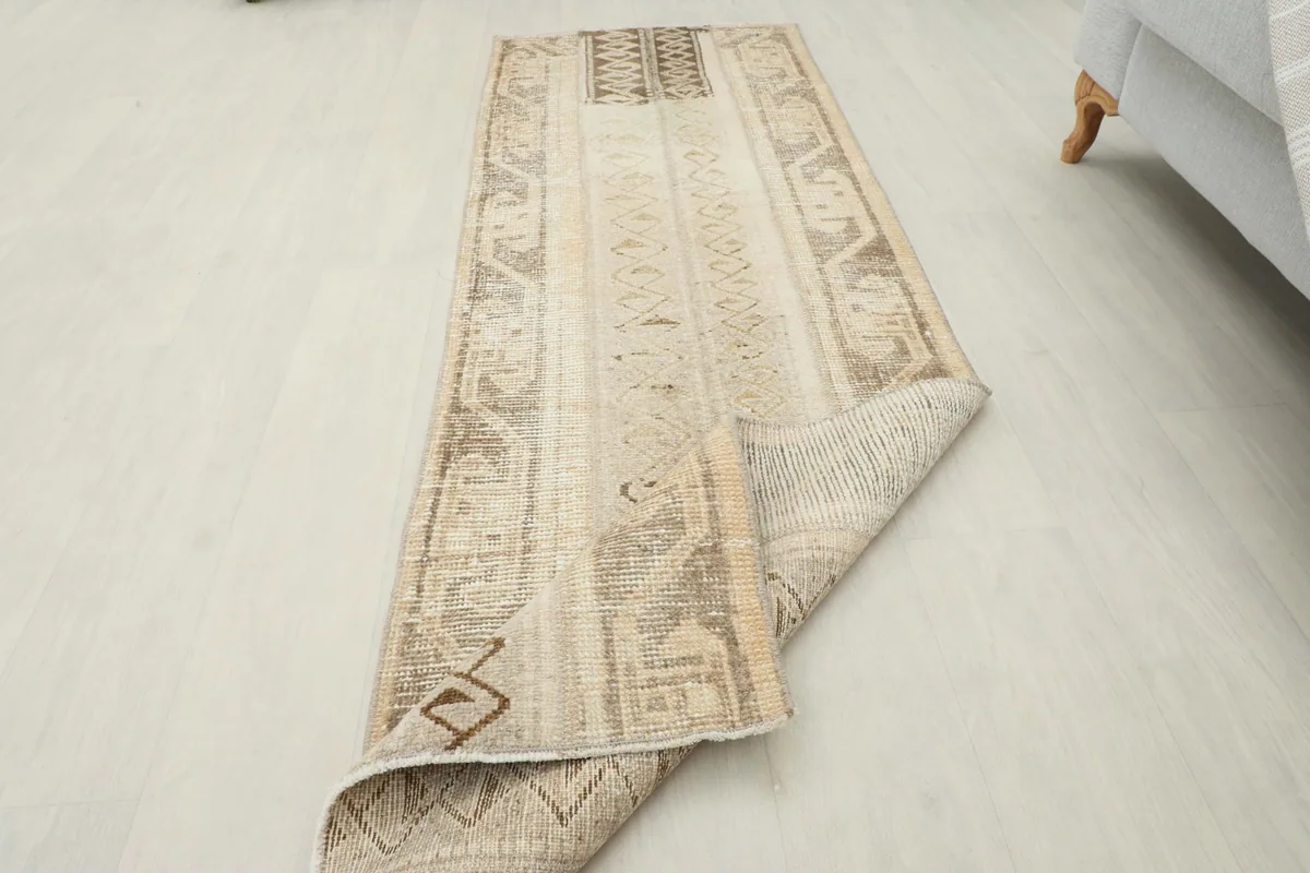 Angled view of the runner with a corner folded back, displaying the underside and pile.